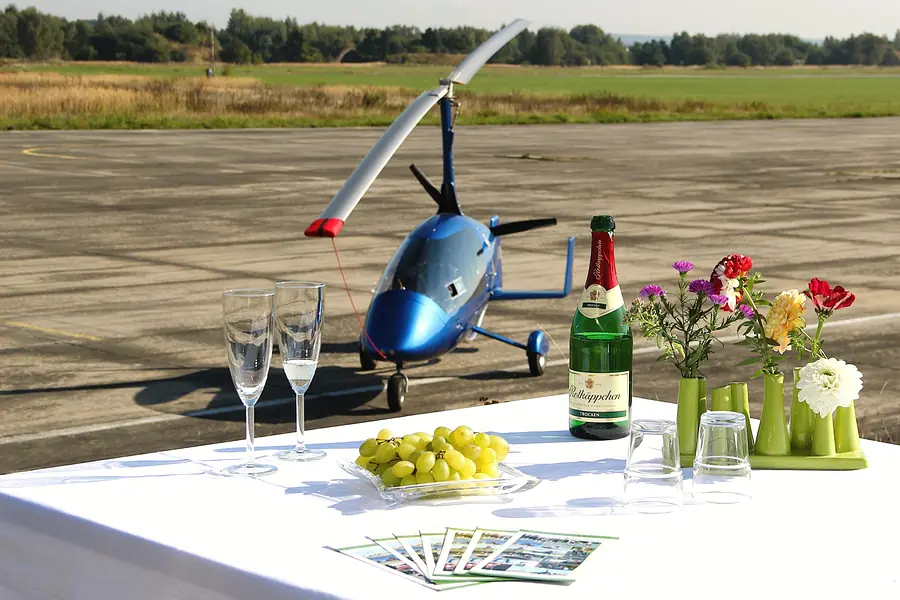 Sektempfang am Flugplatz, im Hintegrund ein blauer Gyrocopter zum Rundflug bereit